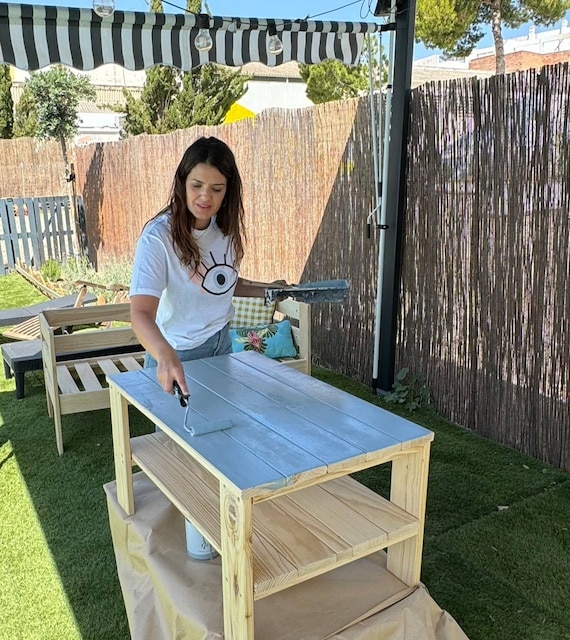 Gema pintando la mesa de exterior